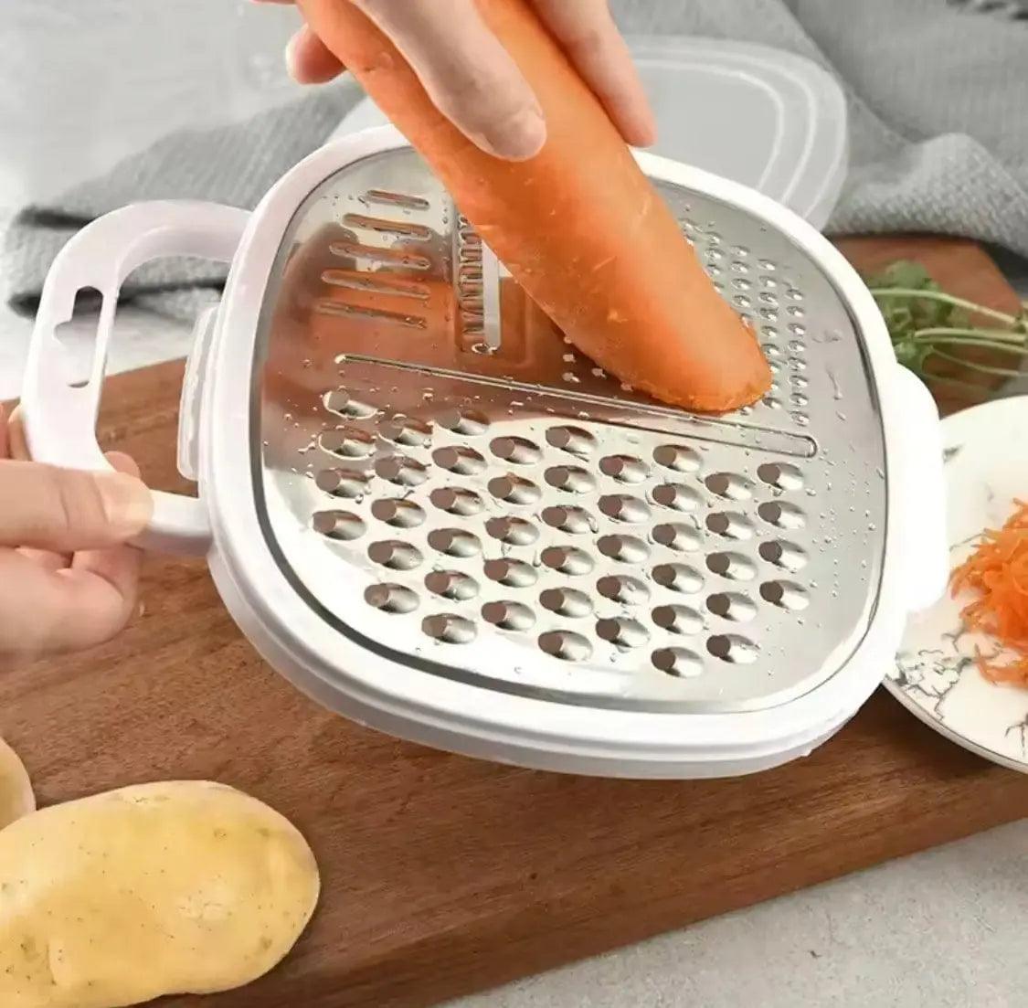 Person grating a carrot on a multi-function stainless steel vegetable grater with white side handles.