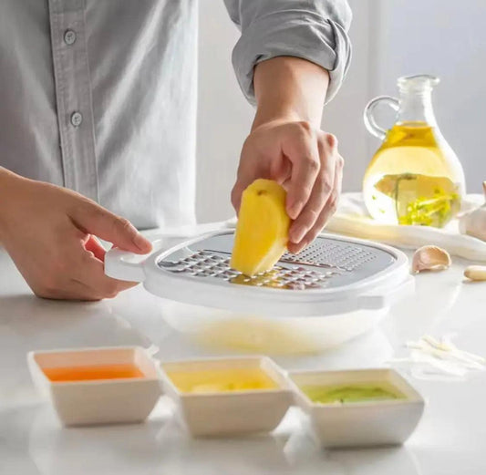 Person grating a yellow vegetable on a multi-function kitchen grater positioned over a white storage bowl.