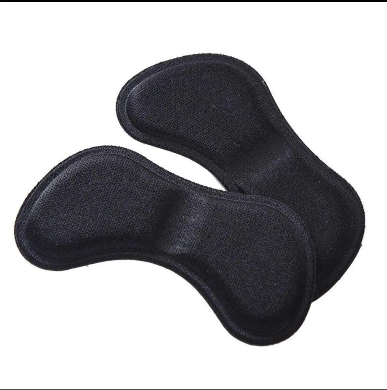 Pair of black fabric-covered heel cushion pads designed to provide soft support and improve shoe fit.