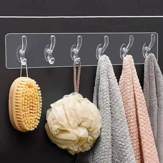 Heavy-duty transparent adhesive wall hook strip with multiple hooks for organizing towels, clothes, kitchen tools, bathroom accessories, and home essentials without damaging walls.