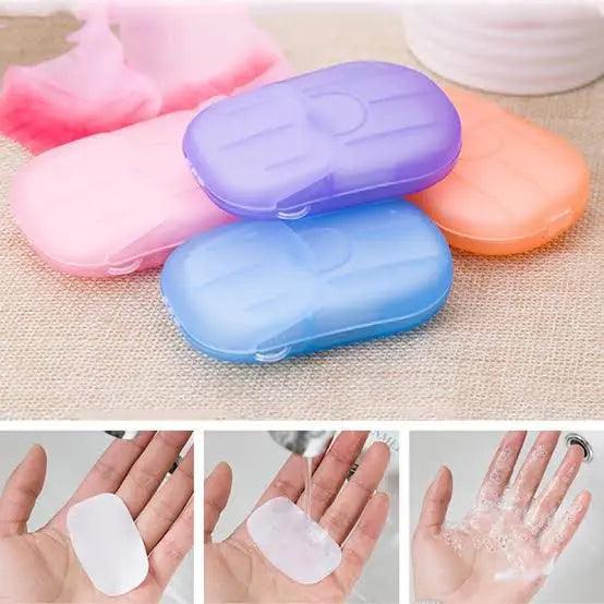 Pink, purple, blue, and orange travel cases for paper soap sheets, with steps showing a soap sheet dissolving in water for hand washing.