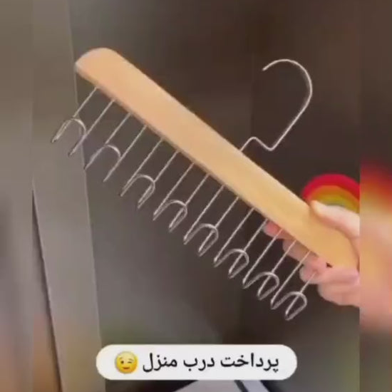 Video showing a dark wooden multi-hook hanger with metal hooks for neatly organizing clothes and wardrobe accessories.