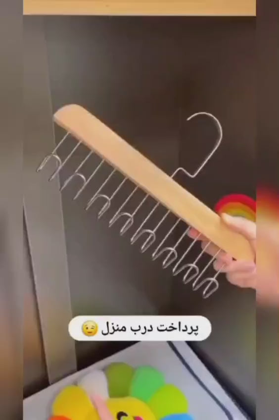 Video showing a dark wooden multi-hook hanger with metal hooks for neatly organizing clothes and wardrobe accessories.